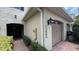 Townhouse showing brick-paved walkway, an attached garage, and a decorative outdoor light fixture at 13885 Arclid St, Orlando, FL 32832