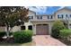 Charming townhouse featuring a red brick driveway, an attached garage, and mature landscaping at 13885 Arclid St, Orlando, FL 32832