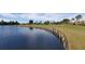 Picturesque view of a serene lake bordering a well-manicured golf course with a retaining wall at 13885 Arclid St, Orlando, FL 32832