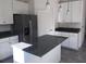 Kitchen with stainless steel refrigerator, center island, and white cabinets at 13885 Arclid St, Orlando, FL 32832