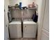 Functional laundry room with a side-by-side washer and dryer, plus shelving for storage at 13885 Arclid St, Orlando, FL 32832
