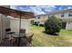 Outdoor patio area with table and umbrella, surrounded by a well-maintained lawn and privacy fence at 13885 Arclid St, Orlando, FL 32832