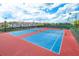 Multiple outdoor tennis courts with lighting and community residences in the background under a blue sky at 13885 Arclid St, Orlando, FL 32832