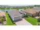 Stunning aerial view of the home showcasing a paver driveway, well-manicured lawn, and a tranquil lake at 142 Olympus Way, Kissimmee, FL 34759