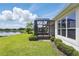 Beautiful backyard view with screened-in patio, lush green lawn, and serene lake view at 142 Olympus Way, Kissimmee, FL 34759