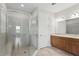 Modern bathroom with glass-enclosed shower featuring a built-in bench and a double sink vanity with ample storage at 142 Olympus Way, Kissimmee, FL 34759