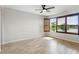Bright bedroom boasts wood-look tile floors, a ceiling fan and window shutters overlooking lush greenery at 142 Olympus Way, Kissimmee, FL 34759