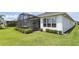 Well-maintained home exterior featuring a screened patio area and manicured lawn at 142 Olympus Way, Kissimmee, FL 34759