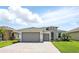 Beautiful single-story home featuring a three-car garage, well-maintained landscaping, and a brick driveway at 142 Olympus Way, Kissimmee, FL 34759
