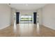 Bright and airy living space with wood-look flooring and sliding glass doors that offer a view of the outdoors at 142 Olympus Way, Kissimmee, FL 34759