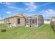 A stucco home equipped with solar panels and a screened-in lanai overlooking the backyard at 143 Brixham Ct, Kissimmee, FL 34758