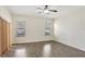 Bedroom features wood-look floors, a ceiling fan, and bright windows at 143 Brixham Ct, Kissimmee, FL 34758