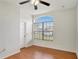 The bedroom offers a large window, hardwood floors, and a ceiling fan at 143 Brixham Ct, Kissimmee, FL 34758