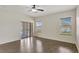 Spacious bedroom with wood-look floors, a ceiling fan, and sliding door access to the patio at 143 Brixham Ct, Kissimmee, FL 34758