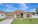 Charming single-story home with a well-manicured lawn and attached two-car garage at 143 Brixham Ct, Kissimmee, FL 34758