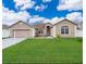 Charming single-story home with a well-manicured lawn and attached two car garage at 143 Brixham Ct, Kissimmee, FL 34758