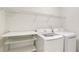 Dedicated laundry room features a washer, dryer, and shelving at 143 Brixham Ct, Kissimmee, FL 34758