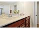 Bathroom featuring double vanity with white countertop, brown cabinetry, mirror and modern faucet at 14389 Lanikai Beach Dr, Orlando, FL 32827
