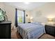 Comfortable bedroom features a window with blinds, nightstands and blue and gray stripped comforter at 14389 Lanikai Beach Dr, Orlando, FL 32827