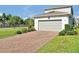 Beautiful home with brick paver driveway, two car garage and nicely manicured bushes at 14389 Lanikai Beach Dr, Orlando, FL 32827