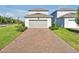 Well maintained front exterior featuring brick paver driveway and nicely landscaped lawn at 14389 Lanikai Beach Dr, Orlando, FL 32827