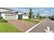 Street view of homes with brick paver driveways, lush lawns and nicely trimmed landscaping at 14389 Lanikai Beach Dr, Orlando, FL 32827
