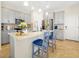 Modern kitchen featuring gray cabinetry, a large island with seating, and stainless steel appliances at 14389 Lanikai Beach Dr, Orlando, FL 32827