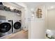 Convenient laundry room with modern washer and dryer, shelving for storage and neutral tones at 14389 Lanikai Beach Dr, Orlando, FL 32827