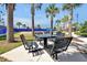 Inviting outdoor seating area with metal tables and chairs, surrounded by palm trees, perfect for relaxing at 14389 Lanikai Beach Dr, Orlando, FL 32827