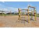 Community playground featuring wooden climbing structures and swings, set in a safe, mulched area at 14389 Lanikai Beach Dr, Orlando, FL 32827