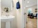 Powder room features pedestal sink, oval mirror, and convenient access to the dining room at 14389 Lanikai Beach Dr, Orlando, FL 32827
