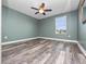 This bedroom features sleek, modern floors, a ceiling fan, and a window that provides natural light at 1470 Lake Side Ave, Davenport, FL 33837