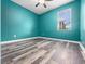 Bedroom with blue walls and wood-look laminate flooring, one window to allow natural light at 1470 Lake Side Ave, Davenport, FL 33837