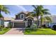 Beautiful two-story home with a tile roof, well-manicured lawn, and mature palm trees at 1470 Lake Side Ave, Davenport, FL 33837