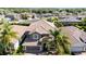 Beautiful two-story home featuring a tile roof, arched entry, two-car garage, and lush tropical landscaping at 1470 Lake Side Ave, Davenport, FL 33837