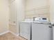 Laundry room with tile floor, washer, dryer and wire rack shelving at 1470 Lake Side Ave, Davenport, FL 33837