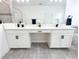 Bathroom featuring a double vanity with white countertops, tiled floors, black hardware, and decorative accents at 1508 Bunker Drive Bunker, Davenport, FL 33896