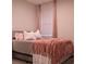 This bedroom features a bed with pink accents and a window with curtains for privacy at 1508 Bunker Drive Bunker, Davenport, FL 33896