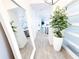 Bright entryway with a large mirror, plant, light wood flooring, and a view into the kitchen at 1508 Bunker Drive Bunker, Davenport, FL 33896