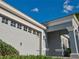 Garage view showcasing the large garage door with decorative windows and black hardware, framed by mature landscaping at 1508 Bunker Drive Bunker, Davenport, FL 33896