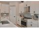 A modern kitchen featuring white cabinetry, stainless steel appliances, quartz countertops, and a stylish mosaic tile backsplash at 1508 Bunker Drive Bunker, Davenport, FL 33896