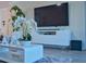 Bright living room with modern decor, including a large flat screen TV and stylish white furniture at 1508 Bunker Drive Bunker, Davenport, FL 33896