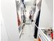 Bright walk-in closet with custom white shelving, hanging clothes, shoe racks, and pull-out drawers on gray flooring at 1508 Bunker Drive Bunker, Davenport, FL 33896