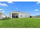 Spacious backyard showcases lush green grass, a covered patio, and a well-maintained exterior at 1524 Fleur Dr, Davenport, FL 33837