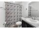 Cozy bathroom features patterned shower curtain, granite countertop and modern sink at 1524 Fleur Dr, Davenport, FL 33837