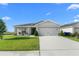 Charming single-story home with a well-manicured lawn and a two-car garage at 1524 Fleur Dr, Davenport, FL 33837