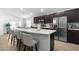 Modern kitchen boasts stainless steel appliances, an island with bar seating, and dark cabinets at 1524 Fleur Dr, Davenport, FL 33837
