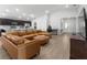 Open-concept living room with leather furniture, kitchen, and wood flooring at 1524 Fleur Dr, Davenport, FL 33837