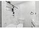 Modern bathroom featuring white marbled shower with black hardware, toilet and sleek white vanity at 1626 Gar St, St Cloud, FL 34771