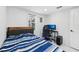 Bright bedroom with wood-look floors, a cozy blue striped bed, and a convenient desk space at 1626 Gar St, St Cloud, FL 34771